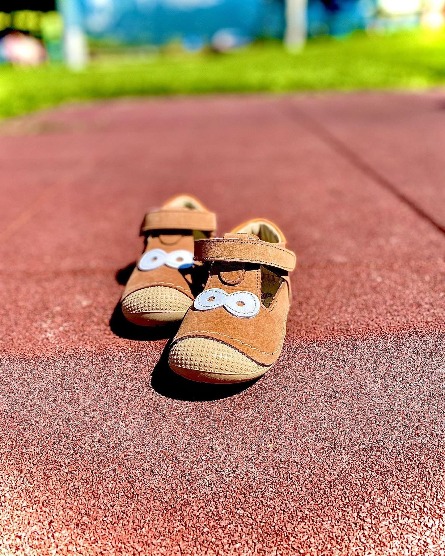 Lauflernschuhe Big Eyes in Braun auf einem schönen Spielplatzboden in Orange